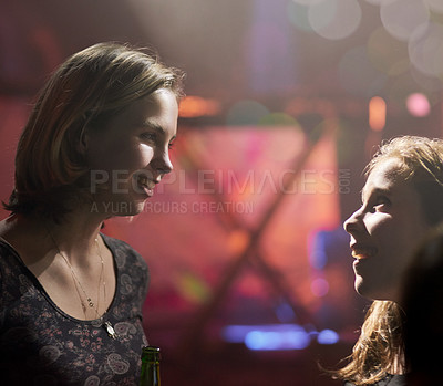 Buy stock photo Women, friends and talking in nightclub for excited conversation with gossip, bokeh lights and bottle. Girls, speaking together and happy at party for birthday with night out, music and social life