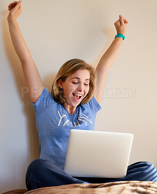 Buy stock photo Shot of an happy young woman reacting to something exciting on her laptop at home