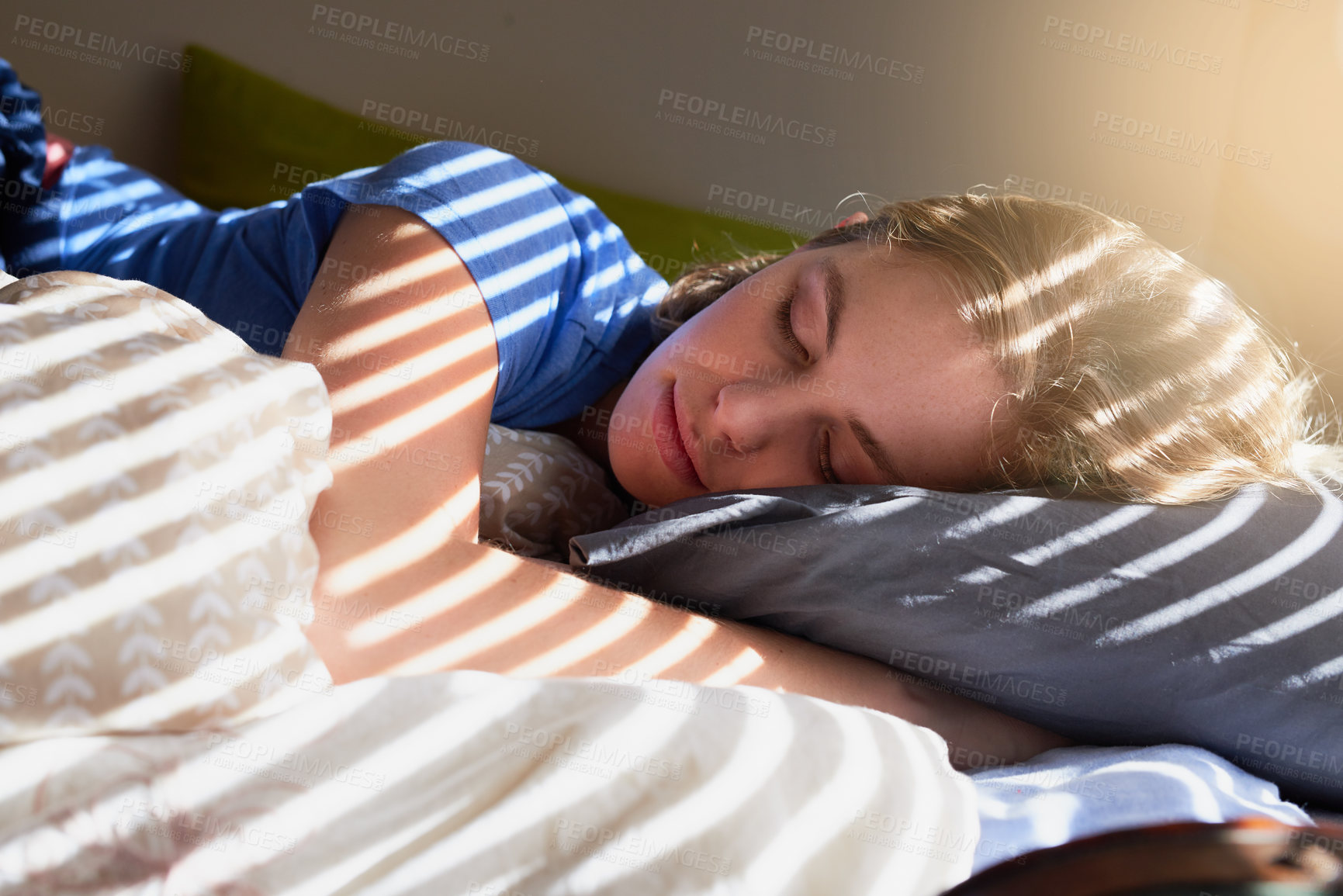 Buy stock photo Shot of a young woman sleeping peacefully in her bed