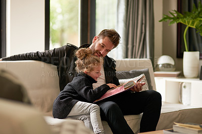 Buy stock photo Cropped shot of a father reading a story to his daughter at home