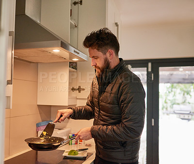 Buy stock photo Cropped shot of a young man cooking at home