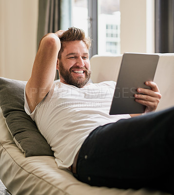 Buy stock photo Cropped shot of a young man using a digital tablet at home