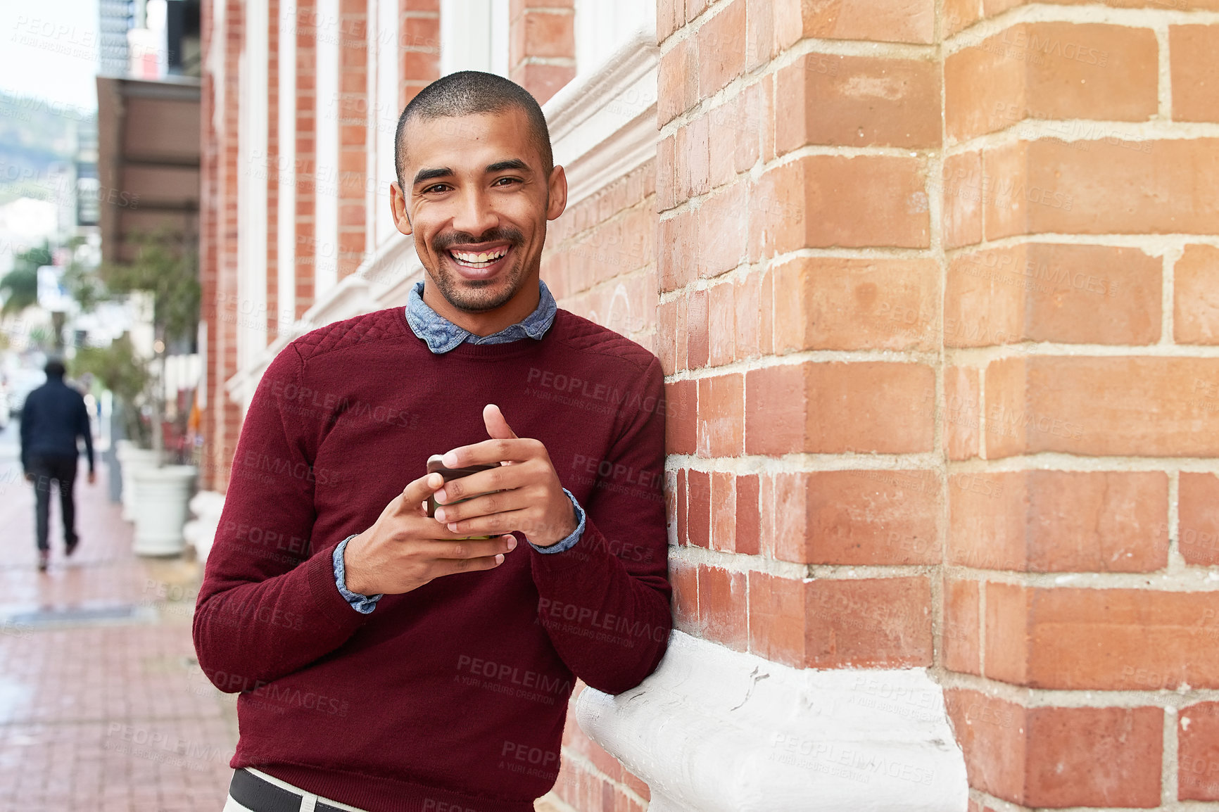 Buy stock photo Portrait shot of a young man texting on a cellphone outside