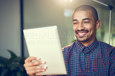 Buy stock photo Cropped shot of a young designer working late on a digital tablet in an office