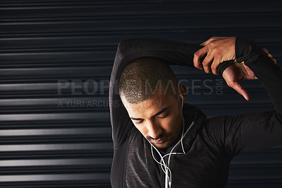 Buy stock photo Shot of an athletic young man warming up before his workout in the gym