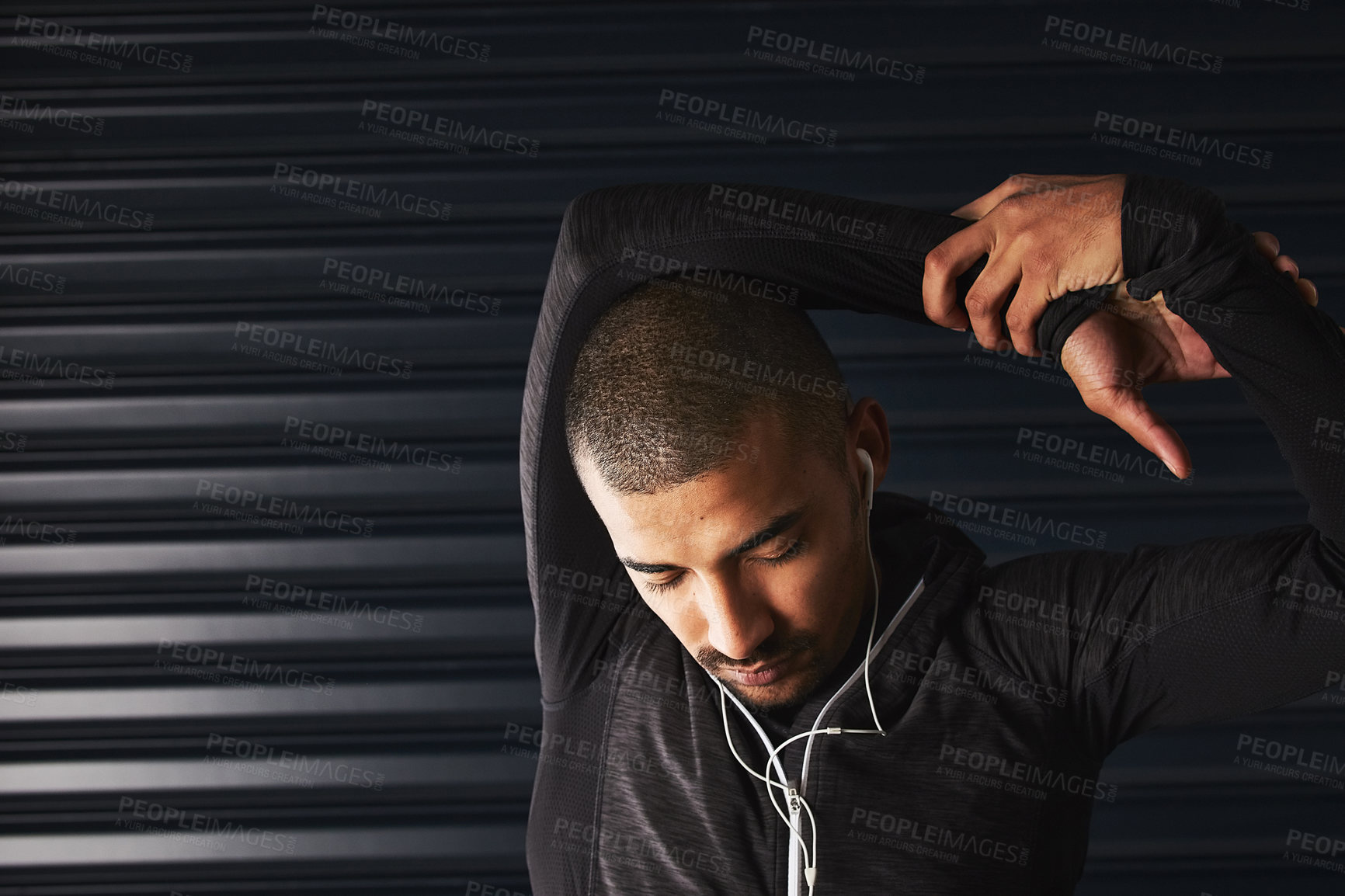 Buy stock photo Shot of an athletic young man warming up before his workout in the gym
