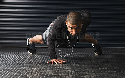 Buy stock photo Shot of an athletic young man doing pushups in the gym