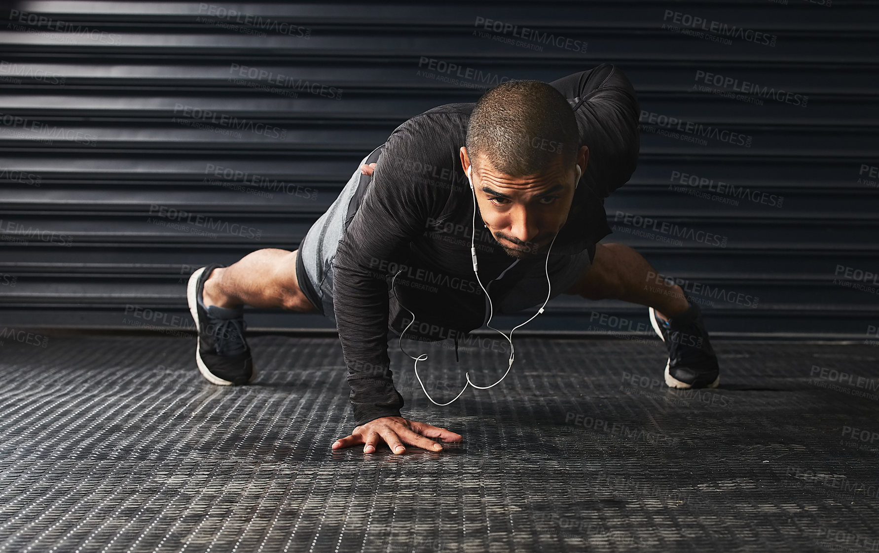 Buy stock photo Shot of an athletic young man doing pushups in the gym