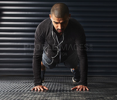 Buy stock photo Shot of an athletic young man doing pushups in the gym