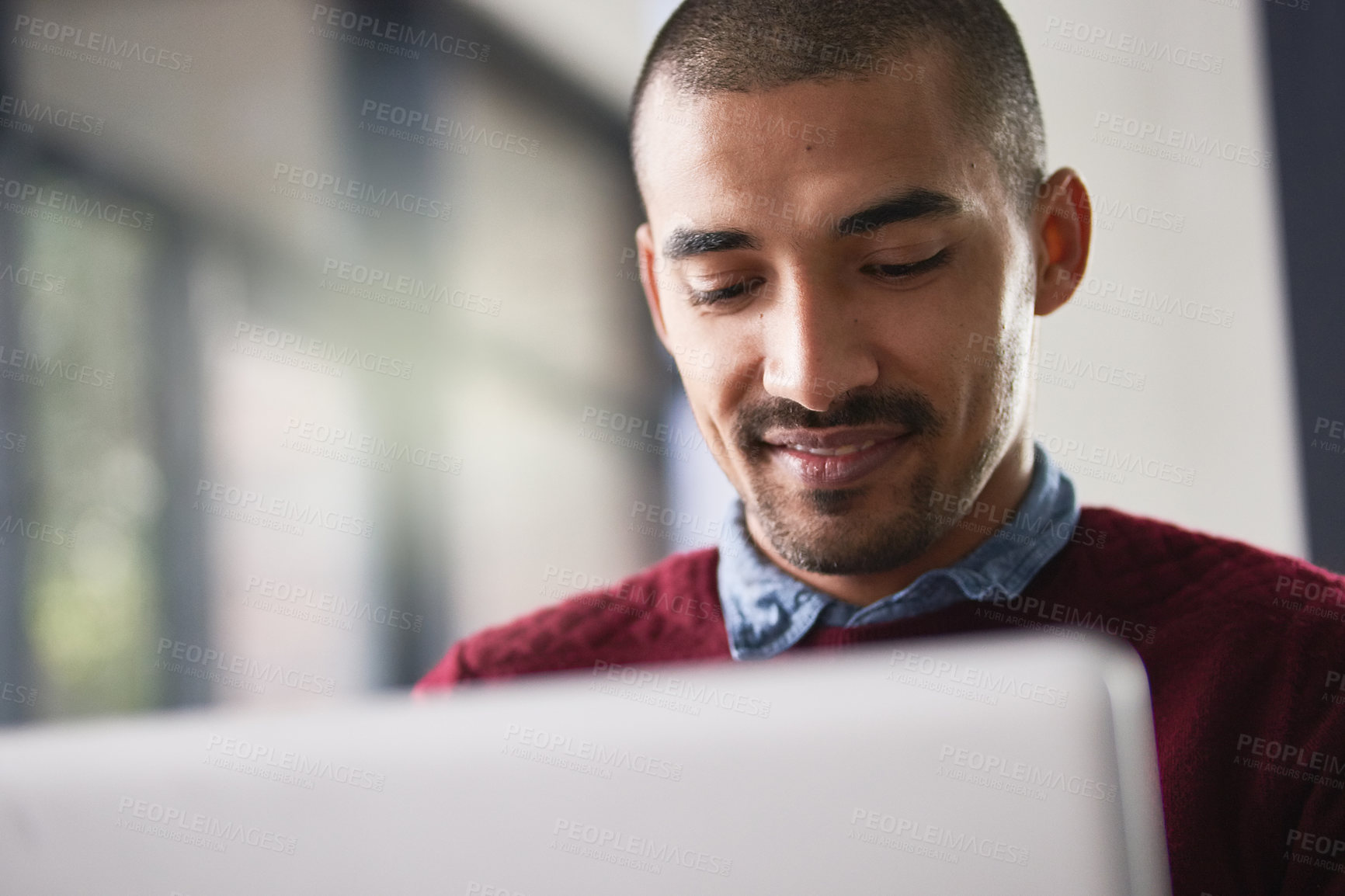 Buy stock photo Cropped shot of a young businessman working on a laptop in an office