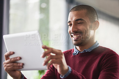Buy stock photo Cropped shot of a young businessman working on a digital tablet in an office