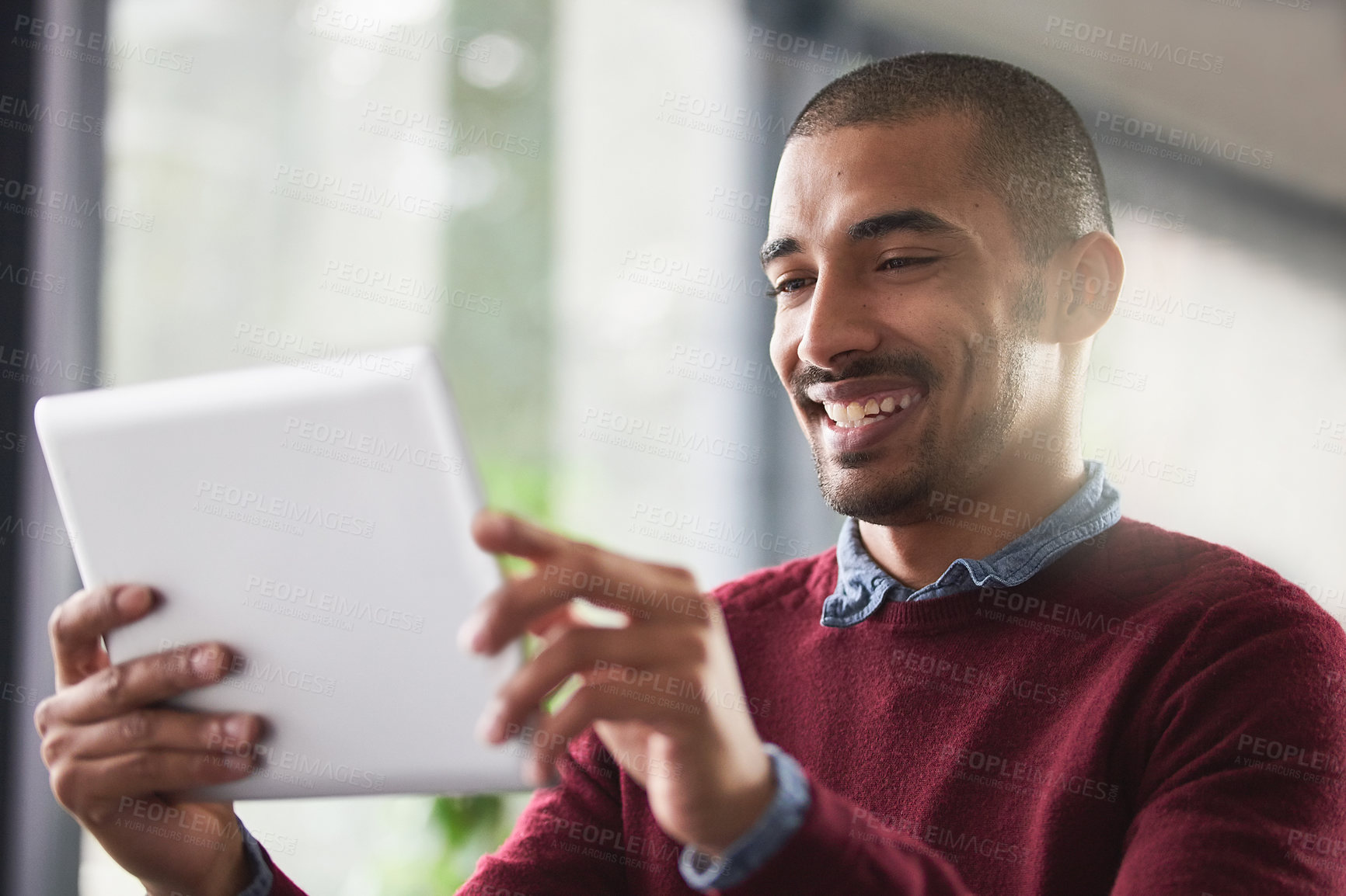 Buy stock photo Cropped shot of a young businessman working on a digital tablet in an office