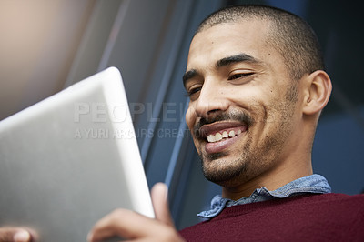 Buy stock photo Cropped shot of a young businessman using a digital tablet outside