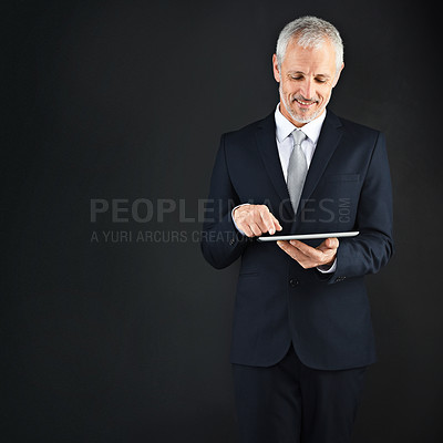 Buy stock photo Mature man, tablet and typing in studio networking on social media, app or internet for communication. Research, browsing and businessman or ceo on digital tech or mockup space by dark background