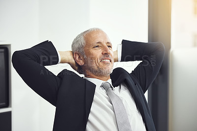 Buy stock photo Shot of a confident mature businessman leaning back in hais chair with his hands behind his head in an office