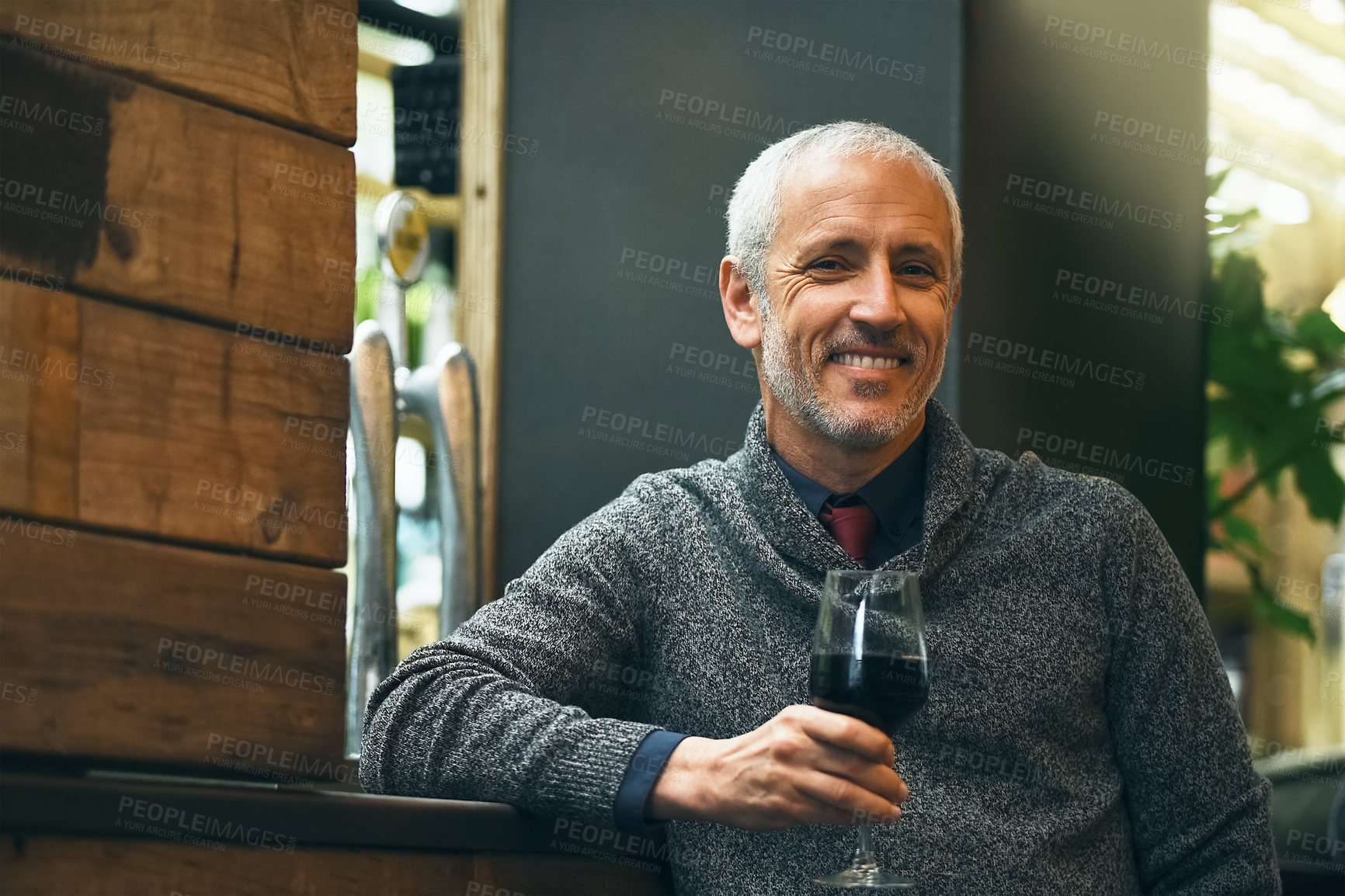 Buy stock photo Portrait of a mature man standing with a glass of red wine in his hand