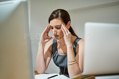 Buy stock photo Shot of a businesswoman suffering from a headache at her office desk