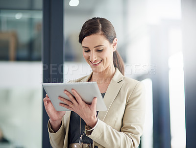 Buy stock photo Shot of a professional businesswoman using a digital tablet at work