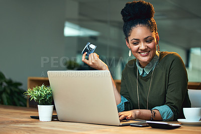 Buy stock photo Shot of an attractive young woman shopping online while working in the office