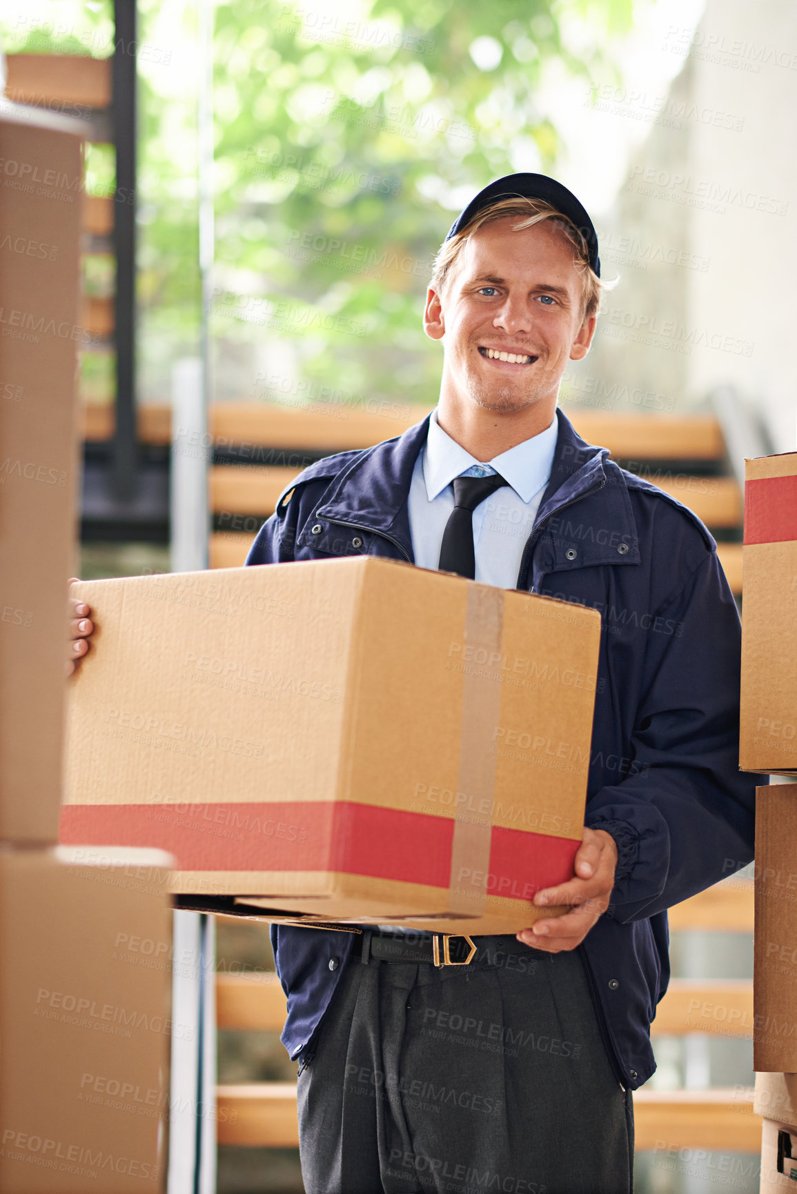 Buy stock photo Shot of a happy courier holding a box