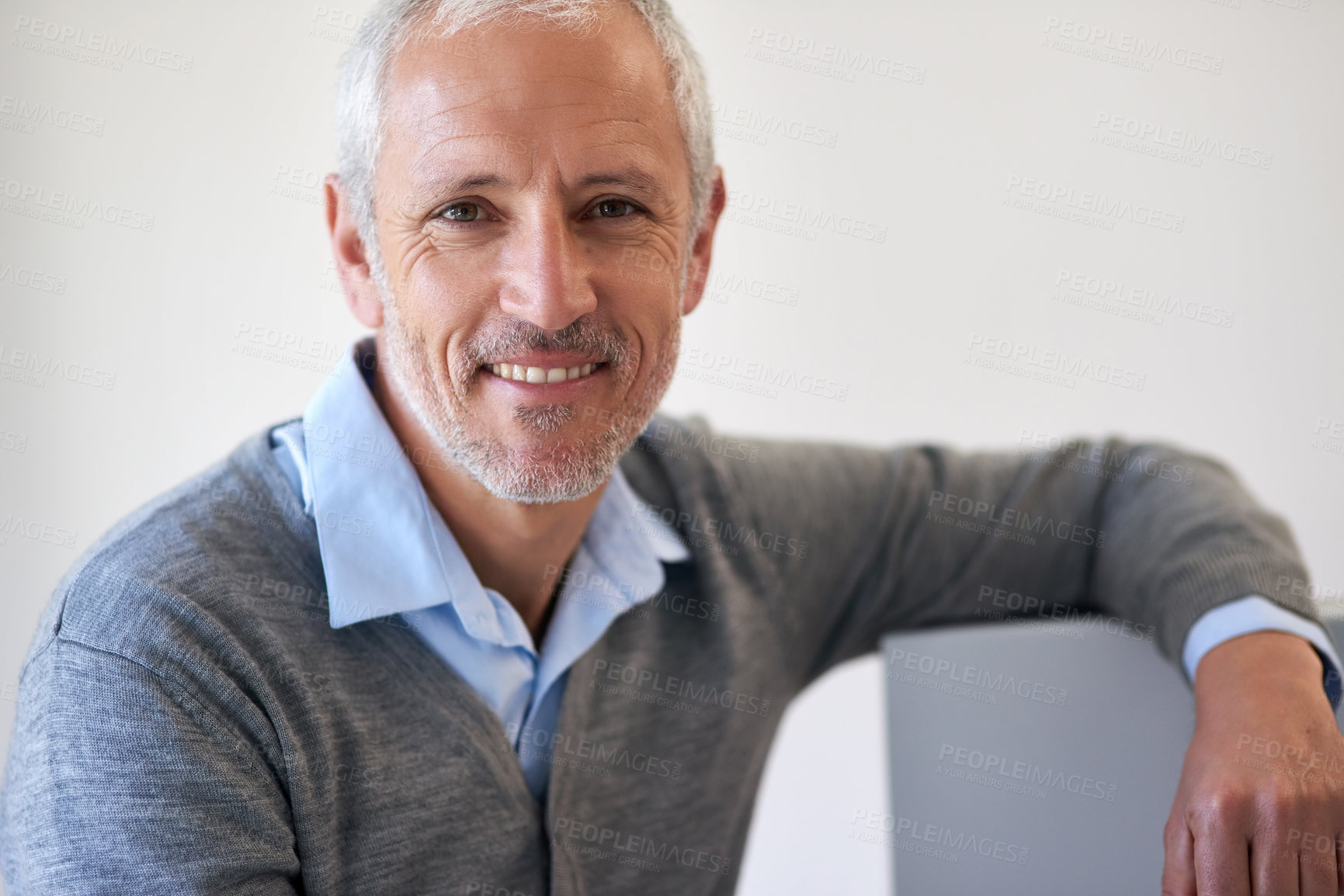Buy stock photo Portrait of a mature businessman leaning on his computer in the office