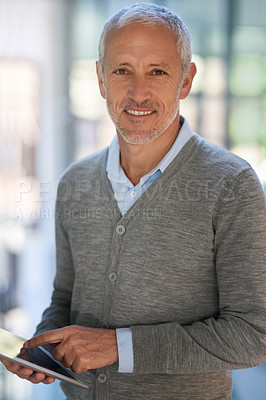 Buy stock photo Portrait of a mature businessman using his digital tablet in the office