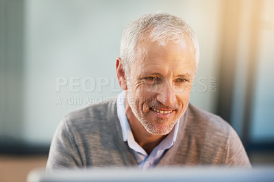Buy stock photo Cropped shot of a mature businessman using his laptop in his office