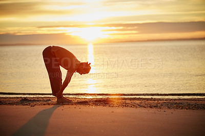 Buy stock photo Shot of a man practicing yoga at the beach during sunset
