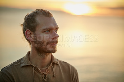 Buy stock photo Shot of a man relaxing at the beach during sunset