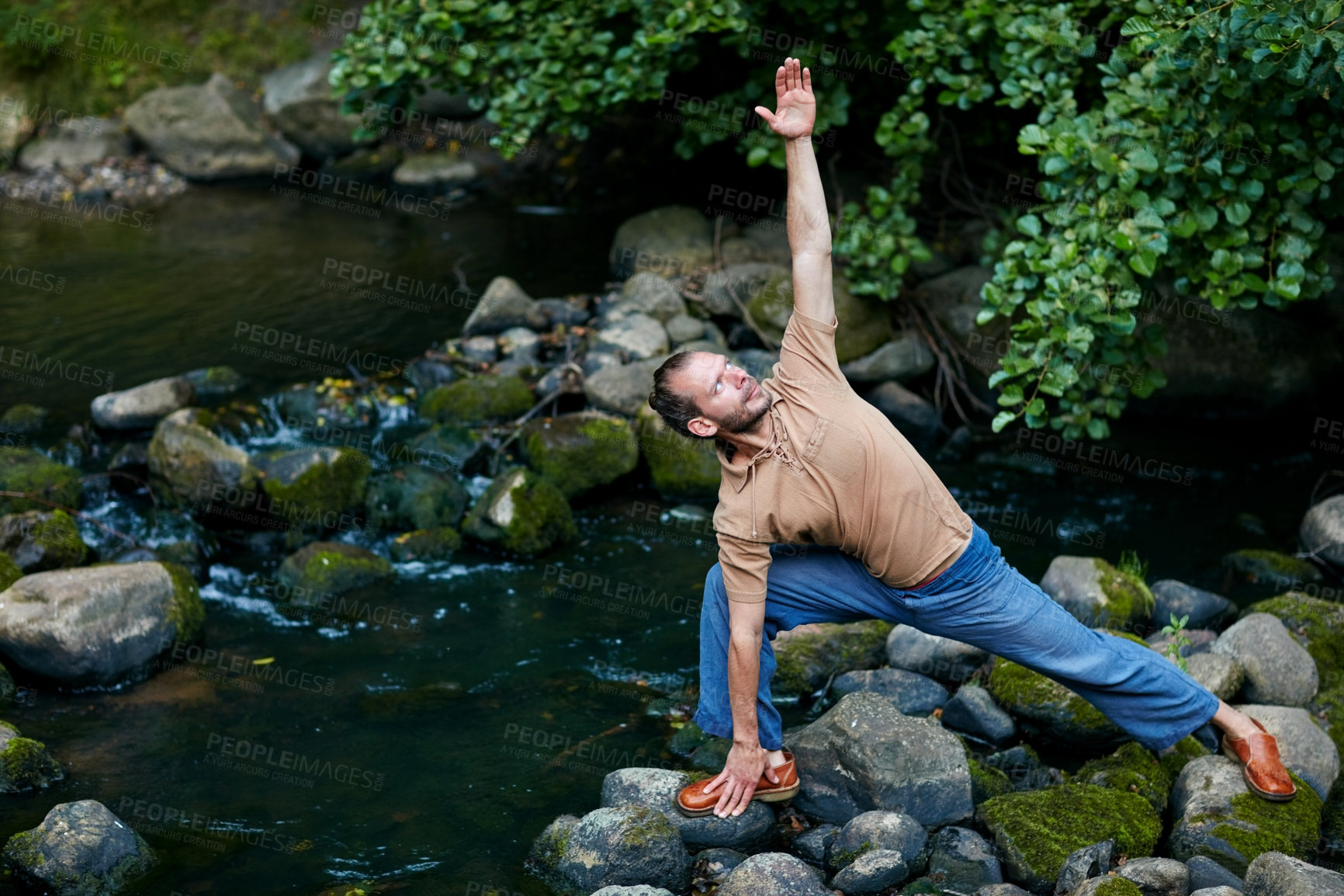 Buy stock photo Shot of a handsome man doing yoga stretches outdoors