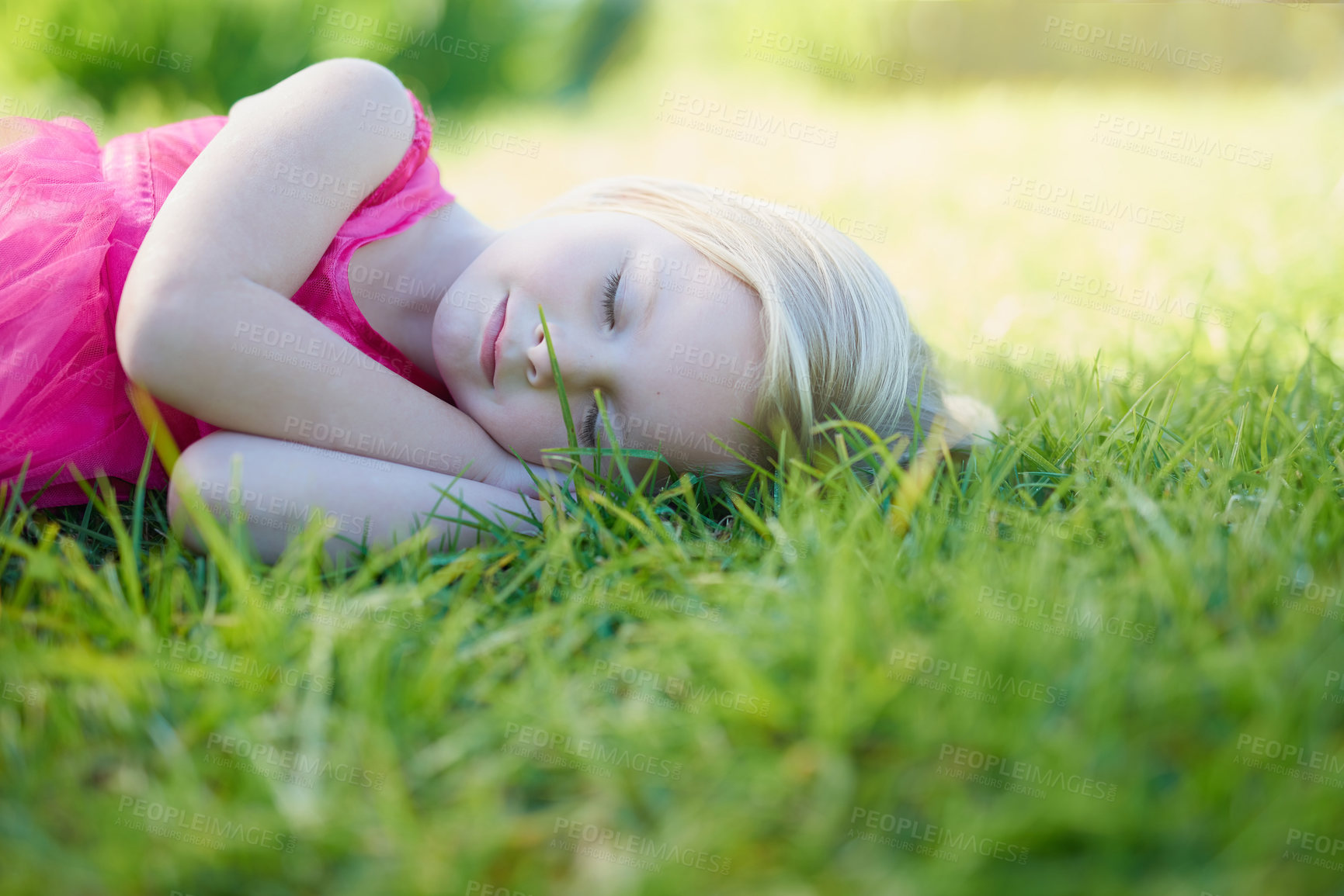 Buy stock photo Cropped shot of a cute little girl sleeping on the grass outside