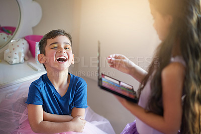 Buy stock photo Shot of a cute little girl playing makeover with her brother at home