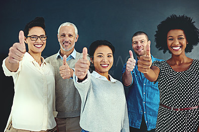 Buy stock photo Portrait of a diverse team of creative colleagues giving you a thumbs up in the studio