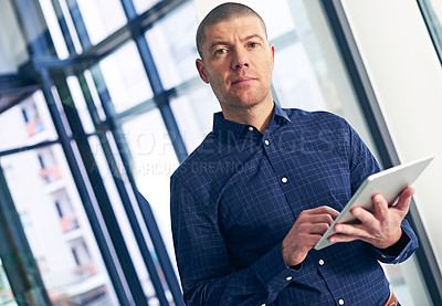 Buy stock photo Portrait of a businessman using a digital tablet in a modern office