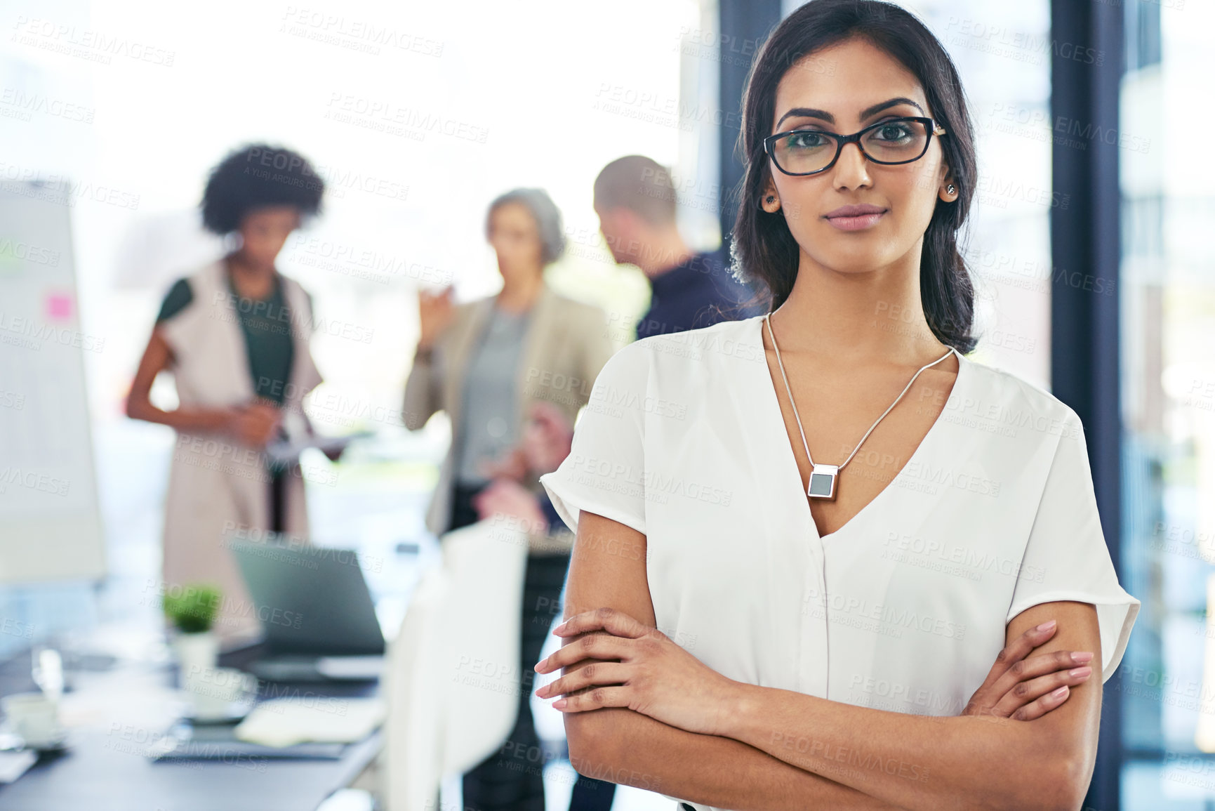 Buy stock photo Portrait of a businesswoman standing in an office with her colleagues in the background