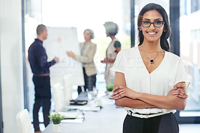 Buy stock photo Portrait of a businesswoman standing in an office with her colleagues in the background
