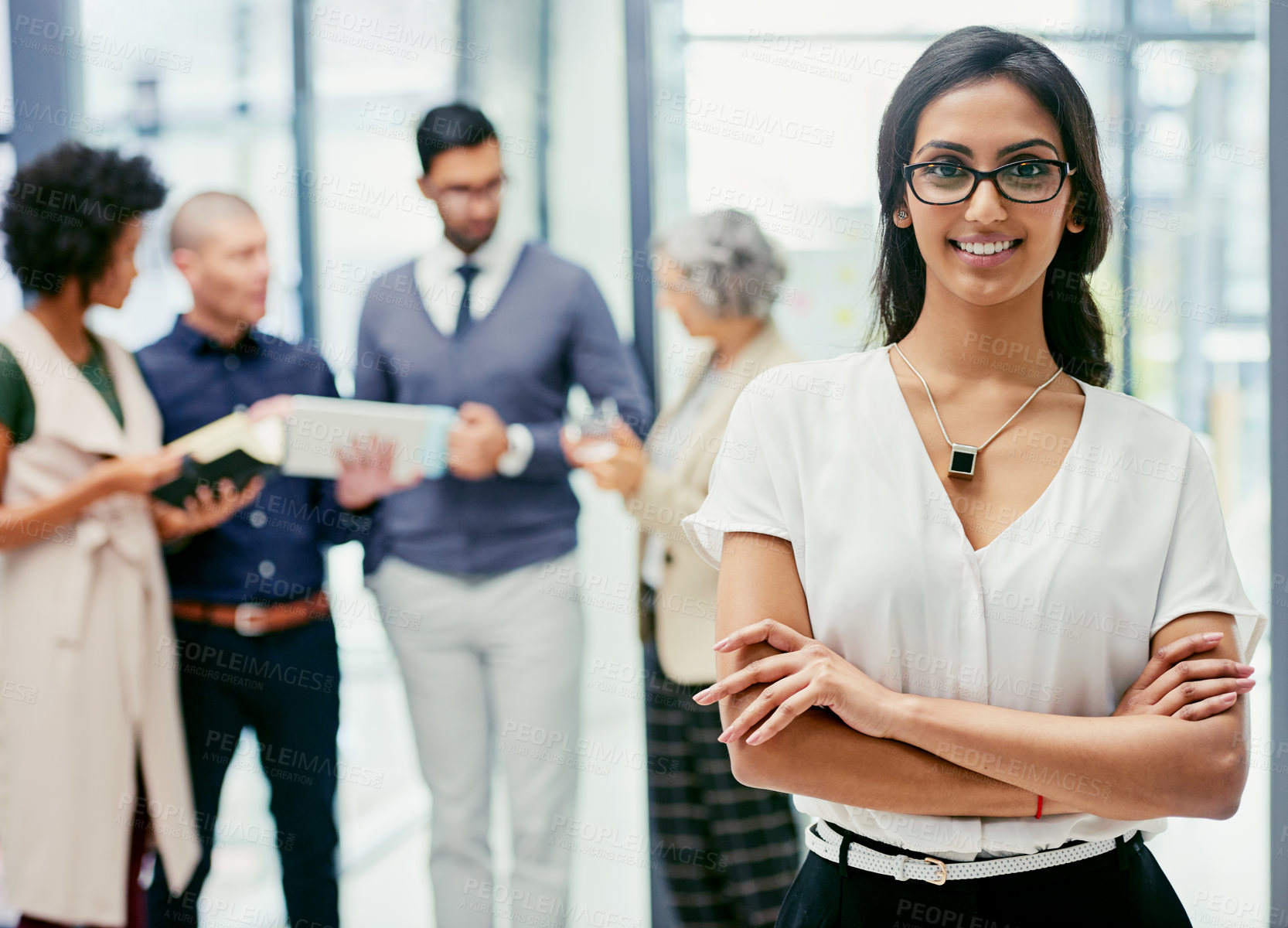 Buy stock photo Portrait of a businesswoman standing in an office with her colleagues in the background