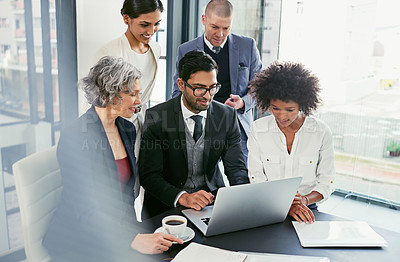 Buy stock photo Shot of a group of businesspeople coming together to discuss something on a laptop