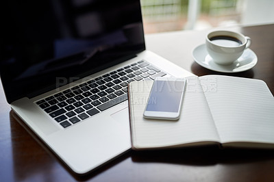 Buy stock photo High angle shot of a laptop, cellphone and notebook on a  table