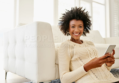 Buy stock photo Portrait of an attractive young using her cellphone while sitting on the floor at home