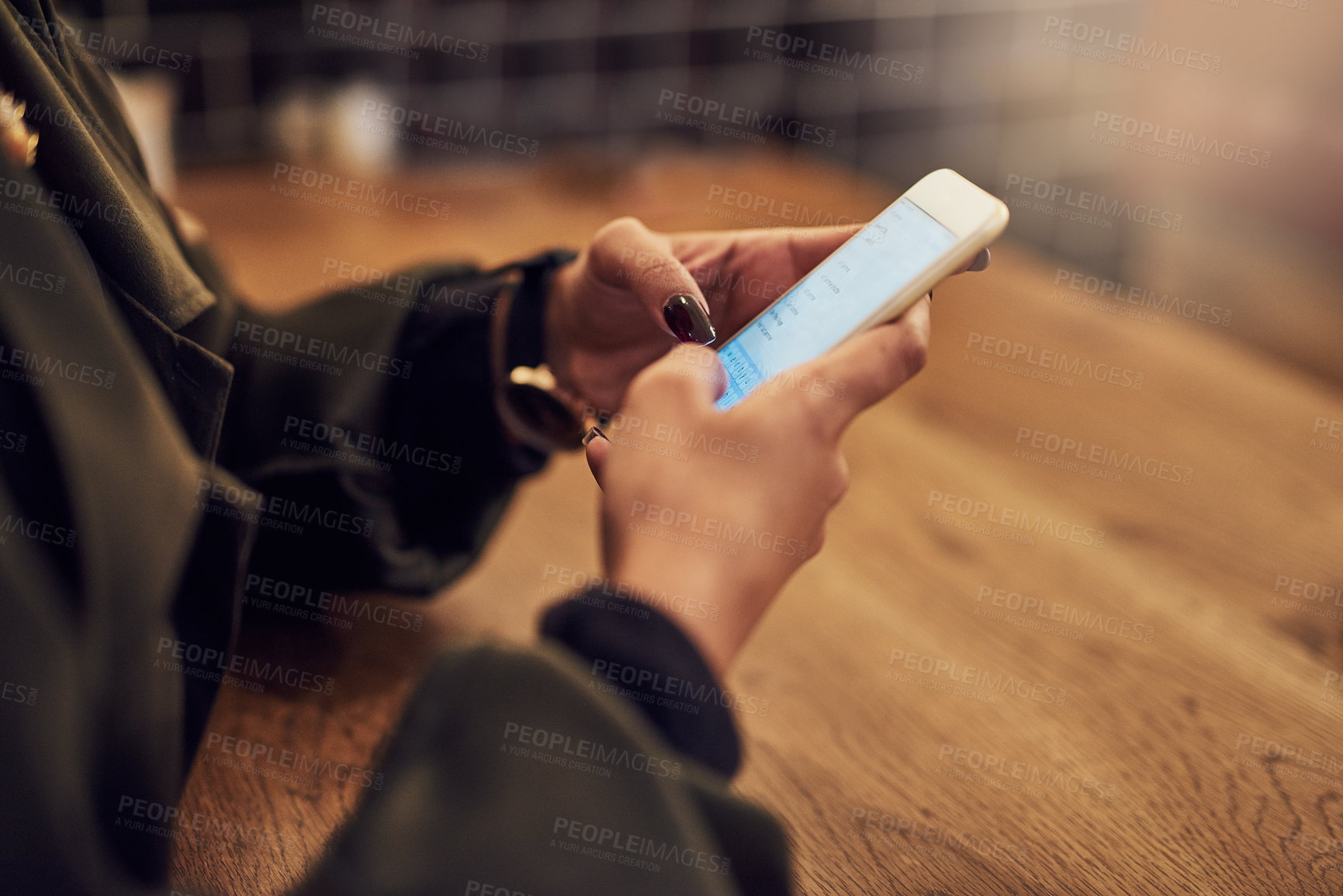 Buy stock photo Cropped shot of a woman using her cellphone in a cafe