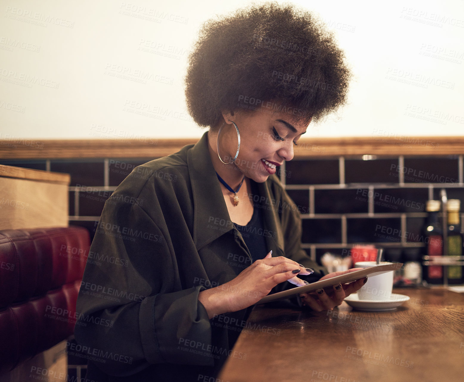 Buy stock photo Cropped shot of a beautiful young woman using a digital tablet in a cafe