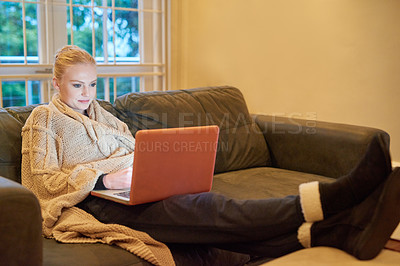 Buy stock photo Woman, laptop and streaming on sofa for movie, tv show or entertainment online. Female person, relaxing and browsing internet in living room for downtime, social media and happy on couch in winter