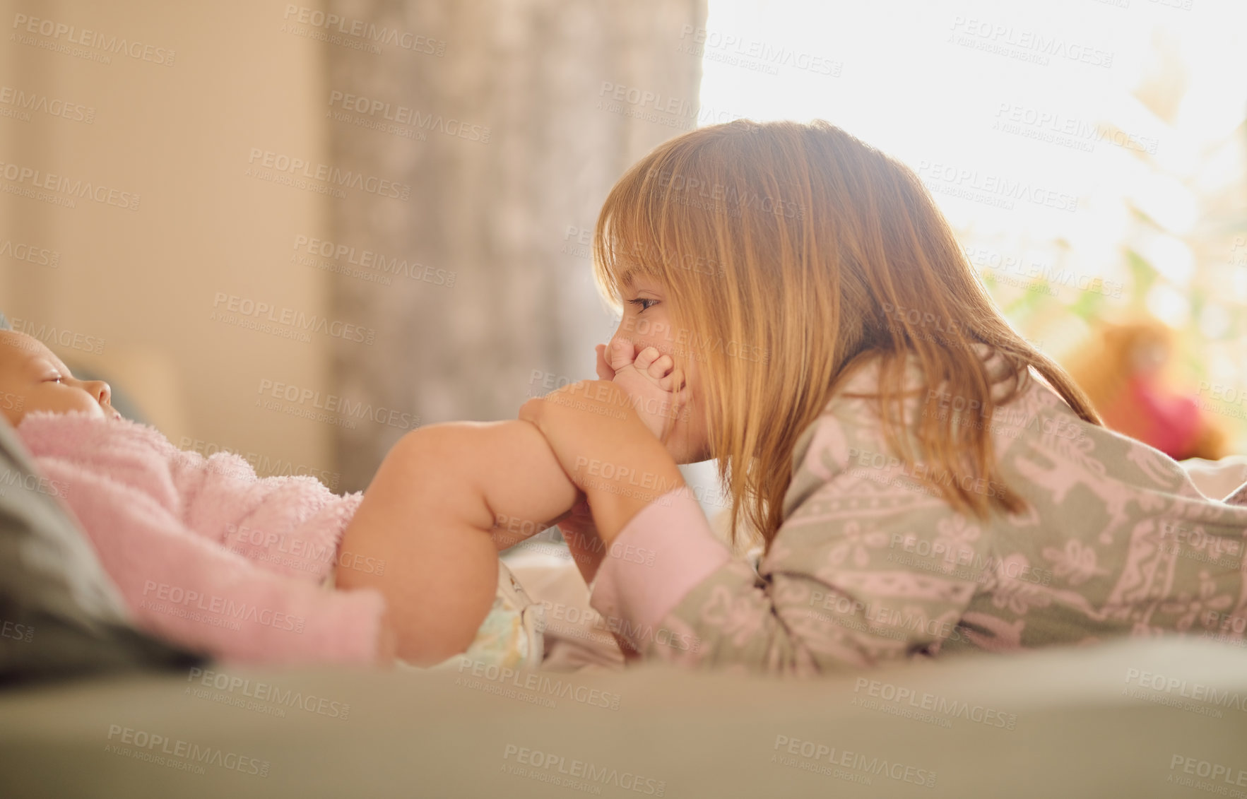 Buy stock photo Family, feet and sister kissing baby girl on bed in home together for care, relationship or support. Bedroom, children and love with sibling kids bonding in apartment for child development or growth