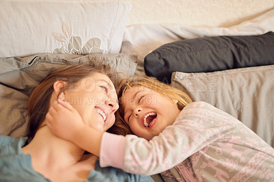 Buy stock photo Shot of a mother and her little girl lying in bed together at home