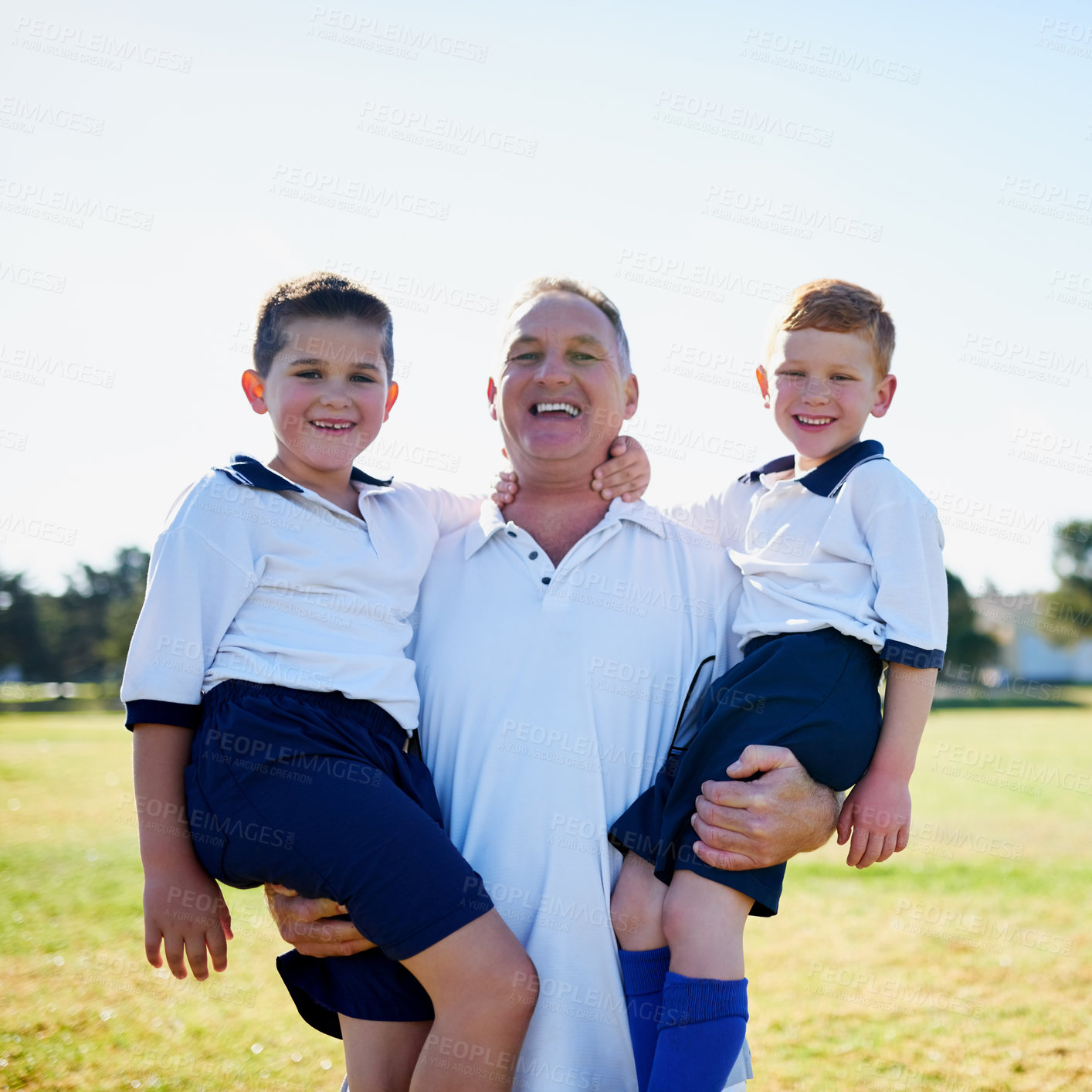 Buy stock photo Portrait of a proud father holding his two sons after a soccer game
