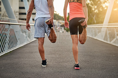 Buy stock photo Rearview shot of a young couple warming up on a bridge before their workout