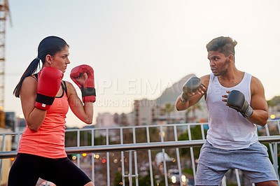 Buy stock photo Boxing, people and outdoor training in city, trainer and fitness or workout for strong power. Couple, town bridge and together for exercise and gloves for practice, teaching and coach for punch