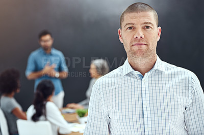 Buy stock photo Portrait of a businessman standing in the boardroom while a colleague gives a presentation in the background