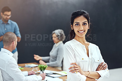 Buy stock photo Portrait of a businesswoman standing with her arms folded in the boardroom while a colleague gives a presentation in the background